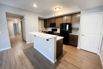 An open kitchen and living room with a white island and black appliances